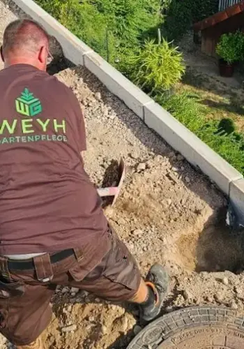 Markus Weyh bei der manuellen Erdarbeit: Vogelperspektive von hinten bei der Gestaltung eines Gartens.